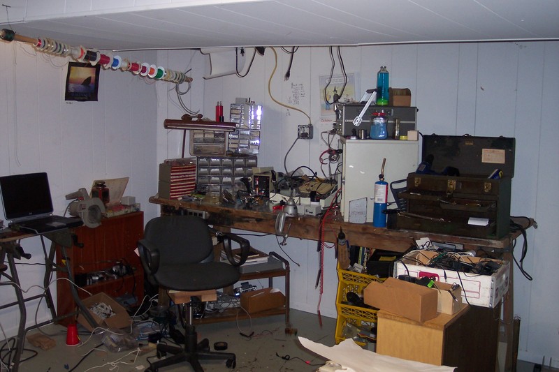 Entire lab.  A large workbench with tools and parts on it, a laptop, some rolling storage containers, shelving holding parts