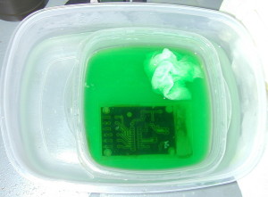 PCB board in a green etching solution
